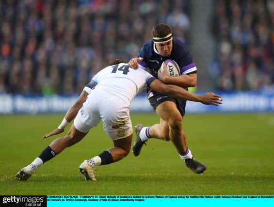 Scotland hooker Stuart McInally is tackled by England's Anthony Watson  at Murrayfield.