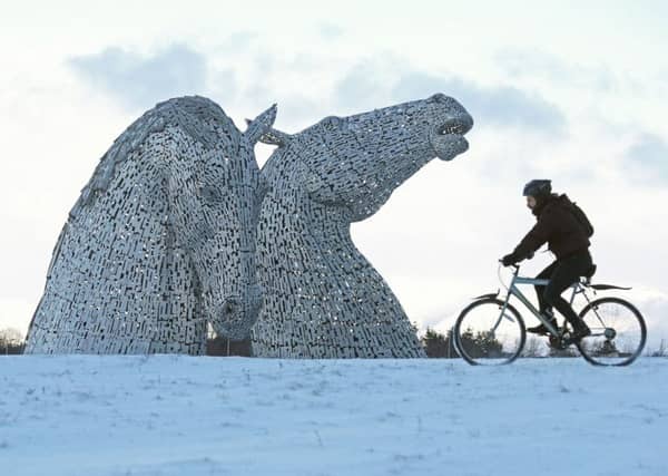 A cyclist braves the elements at the Kelpies. Picture: PA