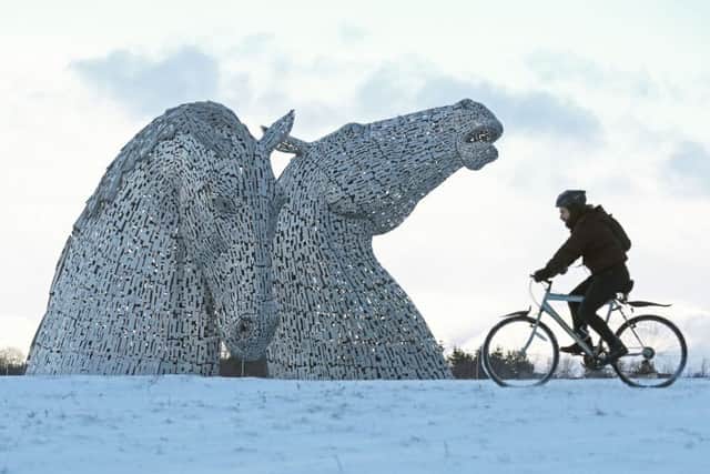 A cyclist braves the elements at the Kelpies. Picture: PA