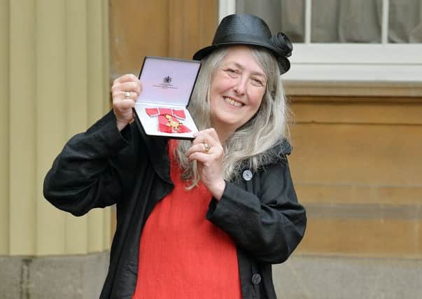 Critics seem obsessed with the appearance and dress sense of Professor Mary Beard, seen holding her OBE medal (Picture: Getty)