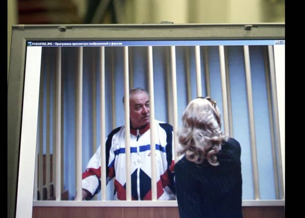 Sergei Skripal speaks to his lawyer from behind bars seen on a screen of a monitor outside a courtroom in Moscow. Picture: AP