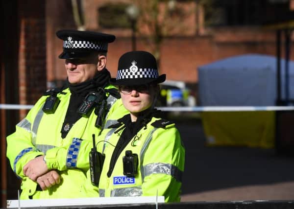 Police stand guard at a cordon at the scene at The Maltings shopping centre in Salisbury, southern England, on March 6, 2018 where a man and a woman were found critically ill on a bench.