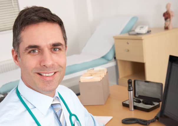 A GP sits at his desk waiting for his next patient to arrive