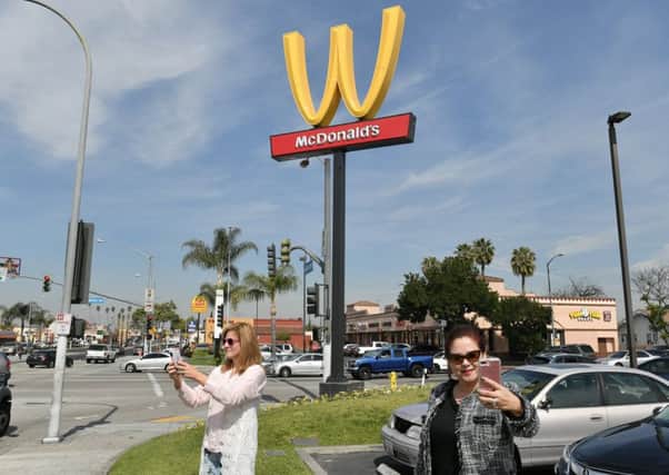 McDonald's turns its sign upside down to make the letter W on International Women's Day in Lynwood, California. Photograph: Neilson Barnard/Getty