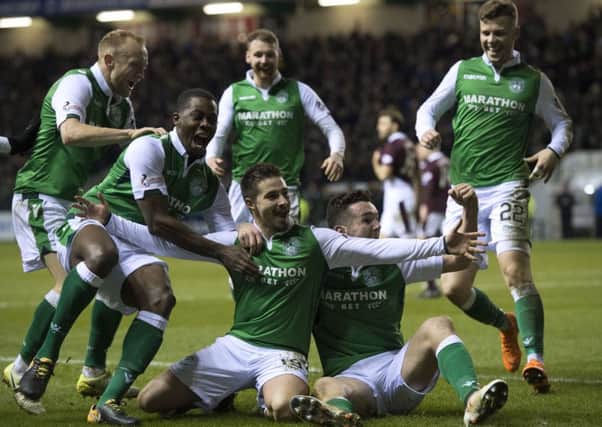Hibs players mob
 Jamie Maclaren, centre, after the Australian's goal clinched a 2-0 win over Hearts at Easter Road. Picture: Ross Parker/SNS