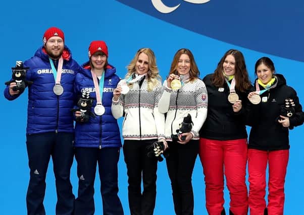 Brett Wild, far left, and Millie Knight on the podium with their silver medals. Picture: Getty.
