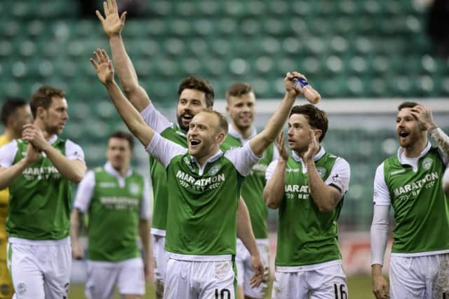 Dylan McGeouch leads the Hibs players in celebration after beating Hearts at Easter Road. Picture: SNS.