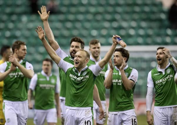 Dylan McGeouch  leads the Hibs players in celebration after beating Hearts at Easter Road. Picture: SNS.