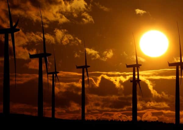 Wind turbines silhouetted against the sun at Black Law wind farm (Picture: Getty)