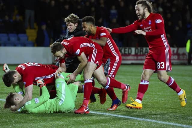 Aberdeen players mob Freddie Woodman at the end of the shoot out. Picture: SNS Group