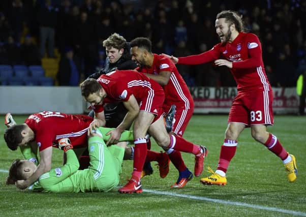 Aberdeen players mob Freddie Woodman at the end of the shoot out. Picture: SNS Group