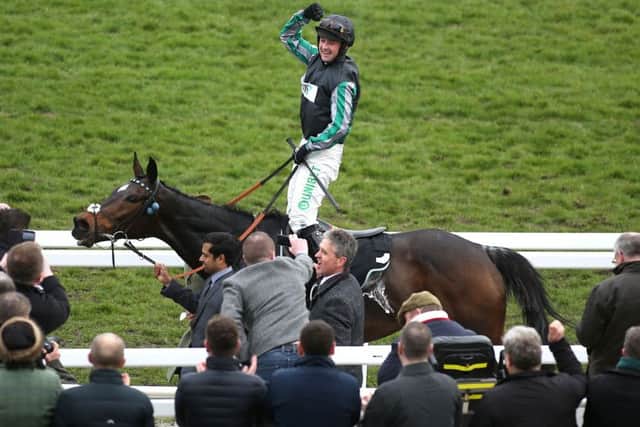 Jockey Nico De Boinville celebrates after Altior's victory in the Champion Chase