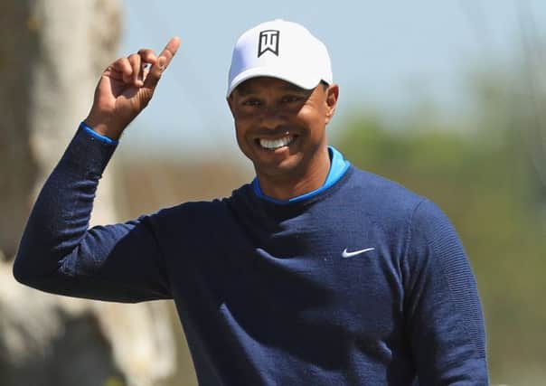 Tiger Woods cracks a smile after holing a monster birdie putt on the seventh. Picture: Mike Ehrmann/Getty Images