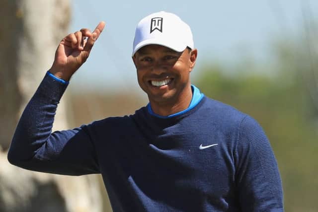 Tiger Woods cracks a smile after holing a monster birdie putt on the seventh. Picture: Mike Ehrmann/Getty Images