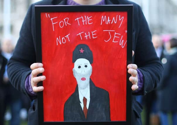 A man holds a sign during a rally and counter-rally in London about anti-semitism in the Labour party (Picture: PA)