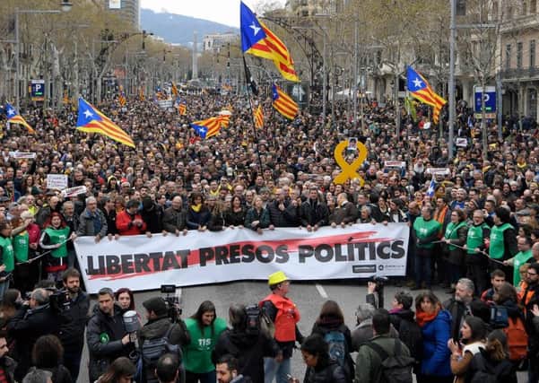 Protesters hold a banner reading "Freedom for political prisoners" while waving pro-independence Catalan Esteleda flags during a demonstration outside the EU Commission offices in Barcelona (Picture: AFP/Getty)