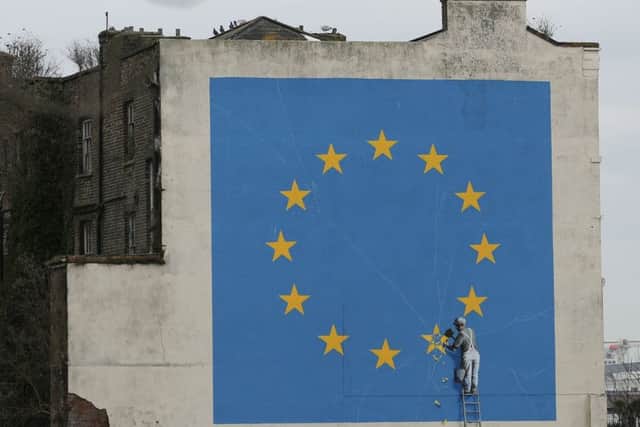 A mural by Banksy in Dover shows a worker chipping away at one of the stars on a European Union flag (Picture: AFP/Getty)