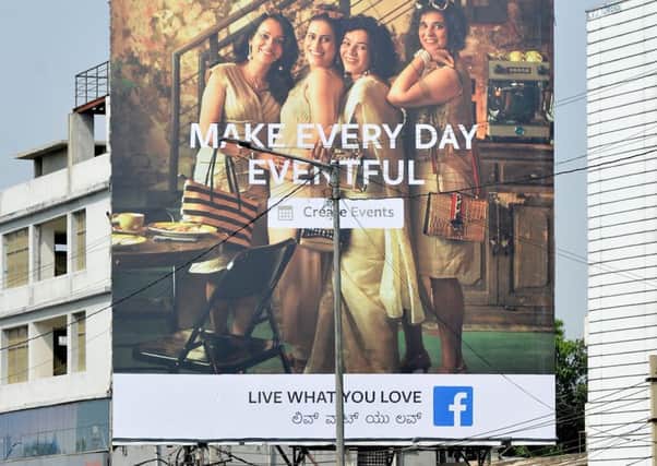 Indian commuters pass a poster advertising Facebook's 'Live What You Love' campaign in Bangalore (Picture: AFP/Getty)