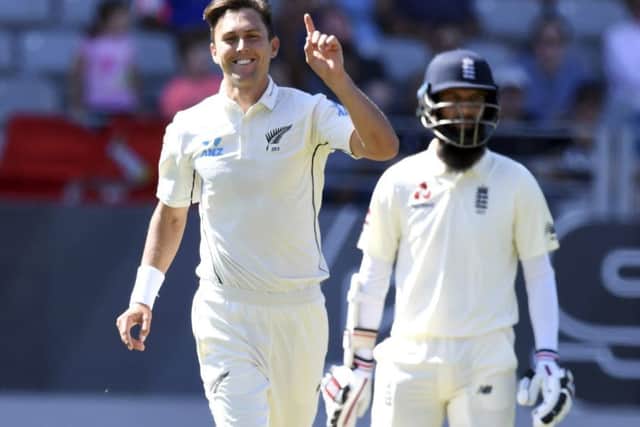 New Zealand's Trent Boult signals his 5th wicket after dismissing England's Chris Woakes, as Moeen Ali looks on. Picture: AP