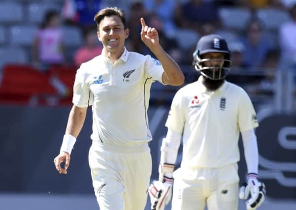 New Zealand's Trent Boult signals his 5th wicket after dismissing England's Chris Woakes, as Moeen Ali looks on. Picture: AP