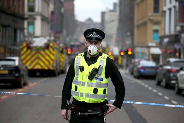 A policeman stands on Sauchiehall Street as fire crews tackle huge blaze. Pic: PA Wire