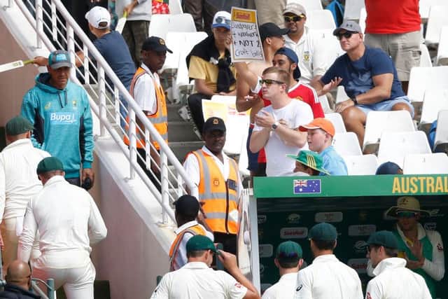 A South African supporter holds a placard reading Sandpapers 4 woodwork + not 2 Croft balls as the Australians leave the filed. Picture: AFP/Getty.