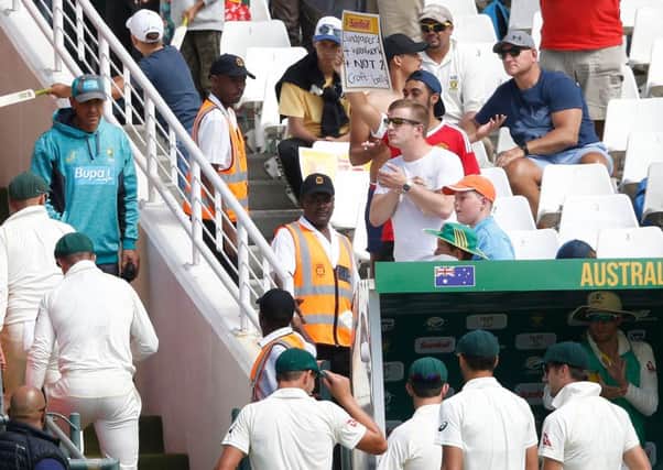 A South African supporter holds a placard reading Sandpapers 4 woodwork + not 2 Croft balls as the Australians leave the filed. Picture: AFP/Getty.