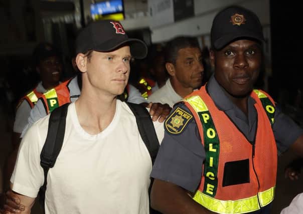 Former Australia captain Steve Smith is escorted by police at Johannesburg airport. Picture: Themba Hadebe/AP