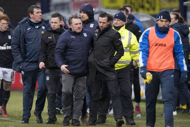 Neil McCann is led away after his altercation with Zander Clark, not pictured. Picture: SNS