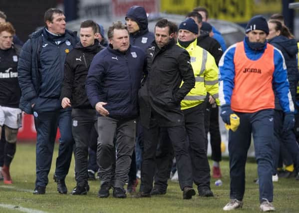 Neil McCann is led away after his altercation with Zander Clark, not pictured. Picture: SNS