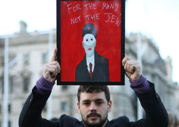 A protester holds a satirical painting at the demonstration in Parliament Square. Picture:
Yui Mok/PA