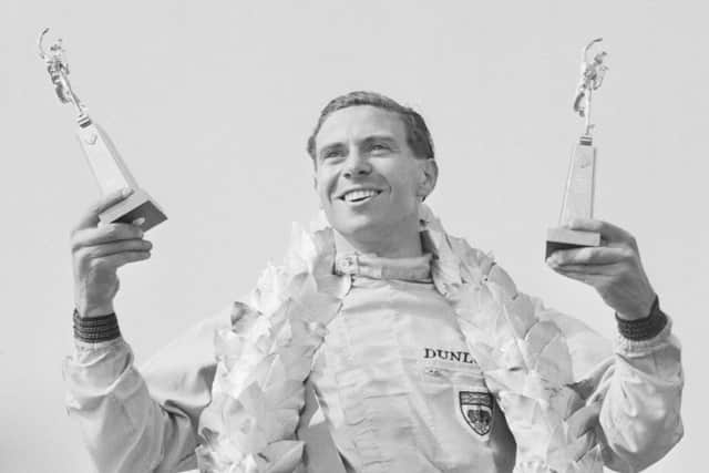 Jim Clark celebrates after winning the British GP at Silverstone. Photograph: Hulton/Getty