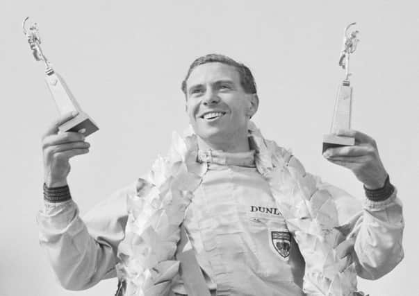 Jim Clark celebrates after winning the British GP at Silverstone. Photograph: Hulton/Getty