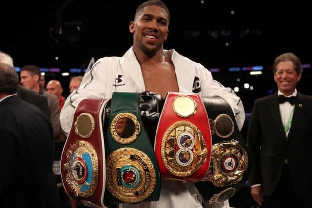 Anthony Joshua celebrates with his belts after victory over Joseph Parker in their WBA, IBF, WBO and IBO Heavyweight Championship contest. Picture: PA