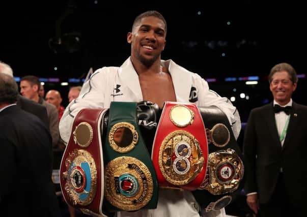 Anthony Joshua celebrates with his belts after victory over Joseph Parker in their WBA, IBF, WBO and IBO Heavyweight Championship contest. Picture: PA