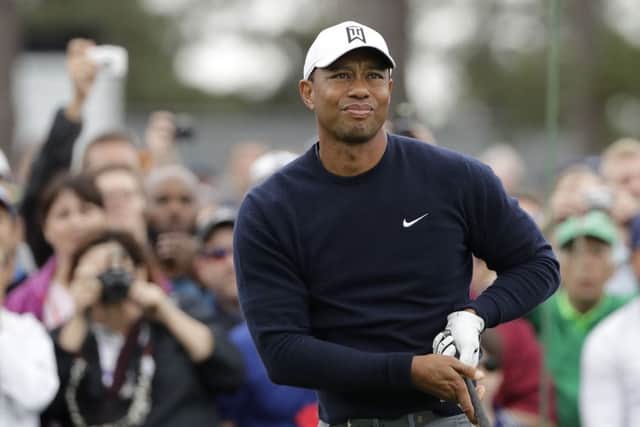 Tiger Woods watches his drive on the first hole during  practice round at Augusta.