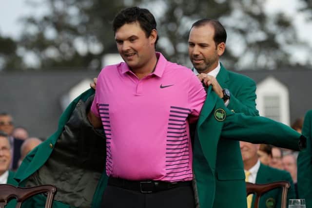 New Masters champion Patrick Reed receives his Green Jacket from 2017 winner Sergio Garcia. Picture: Getty Images