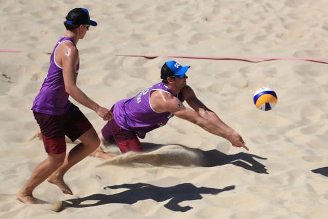 Scotland's Robin Brodzki dives for the ball alongside partner Seain Cook. The Scots were beaten by England. Picture: PA