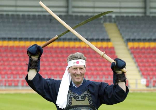 John Lambie gets dressed up to announce Partick Thistle's new club sponsor in 2002.

Picture: Roddy Scott/SNS