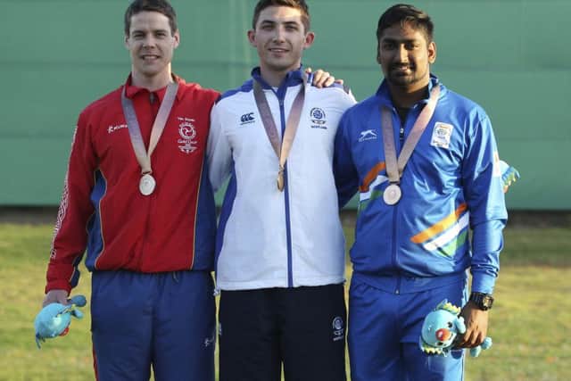 David McMath of Scotland, centre, with his gold meda in the men's double trap, flanked by silver medallist Tim Kneale of the Isle of Man and Ankur Mittal PICTURE: AP