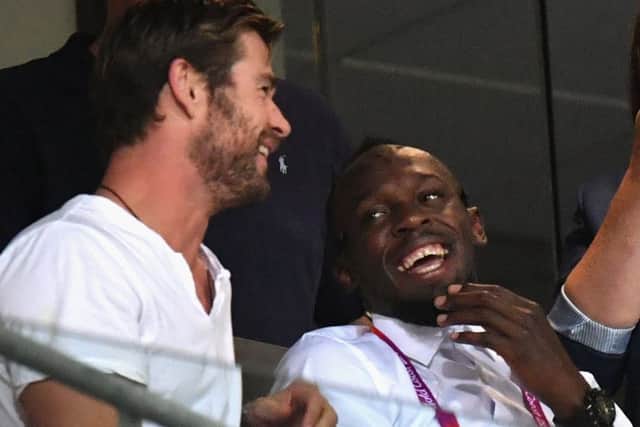 Usain Bolt takes in the athletics action with Australian actor Chris Hemsworth. PICTURE: Getty Images