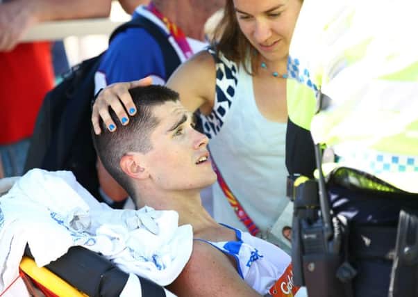 Callum Hawkins is comforted as he receives medical attention following his collapse in the men's marathon PICTURE: Getty Images