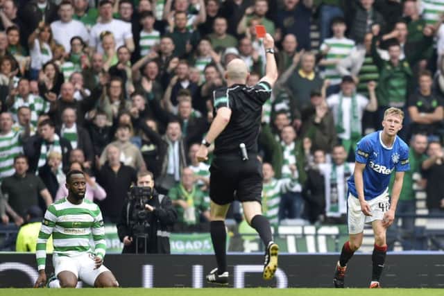 Ross McCrorie is shown the red card by referee Bobby Madden after bringing down Moussa Dembele in the penalty area. Picture: SNS Group