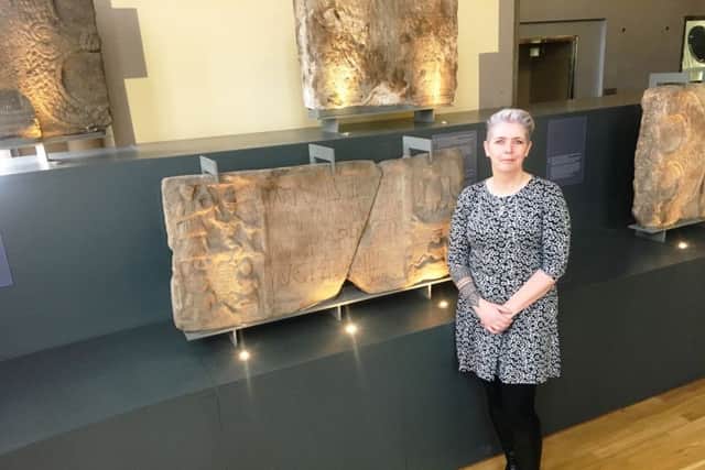 Dr Louisa Campbell  with the Summerston distance stone at the Hunterian Museum at Glasgow University. PIC: Contributed.