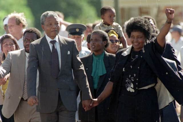 Nelson Mandela is led by his wife, Winnie Mandela, who gives a black power salute, after his release from Victor Verster prison in Cape Town, South Africa, Sunday, Feb. 11, 1990.  The leader of the African National Congress served over 27 years in jail.  (AP Photo/Greg English)