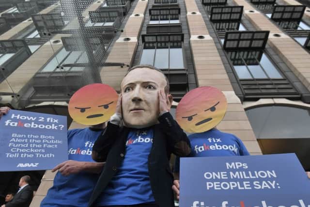 A Mark Zuckerberg figure with people in angry emoji masks outside Portcullis House in Westminster, London. Picture: PA Wire