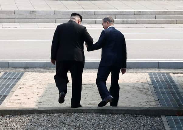 The North and South Korean leaders hold hands on the world's most heavily fortified border (Picture: Getty)