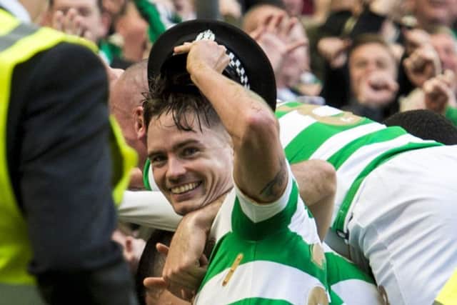 Mikael Lustig with hat as Celtic celebrate their third goal. Picture: SNS