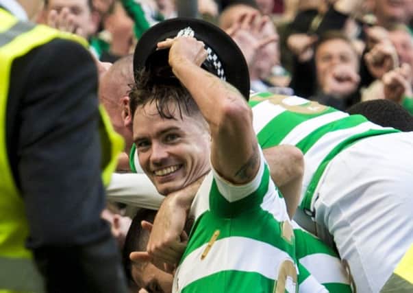Mikael Lustig with hat as Celtic celebrate their third goal. Picture: SNS