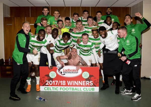 A shirtless Scott Brown leads his players in celebration after clinching the league title yesterday. Picture: SNS.